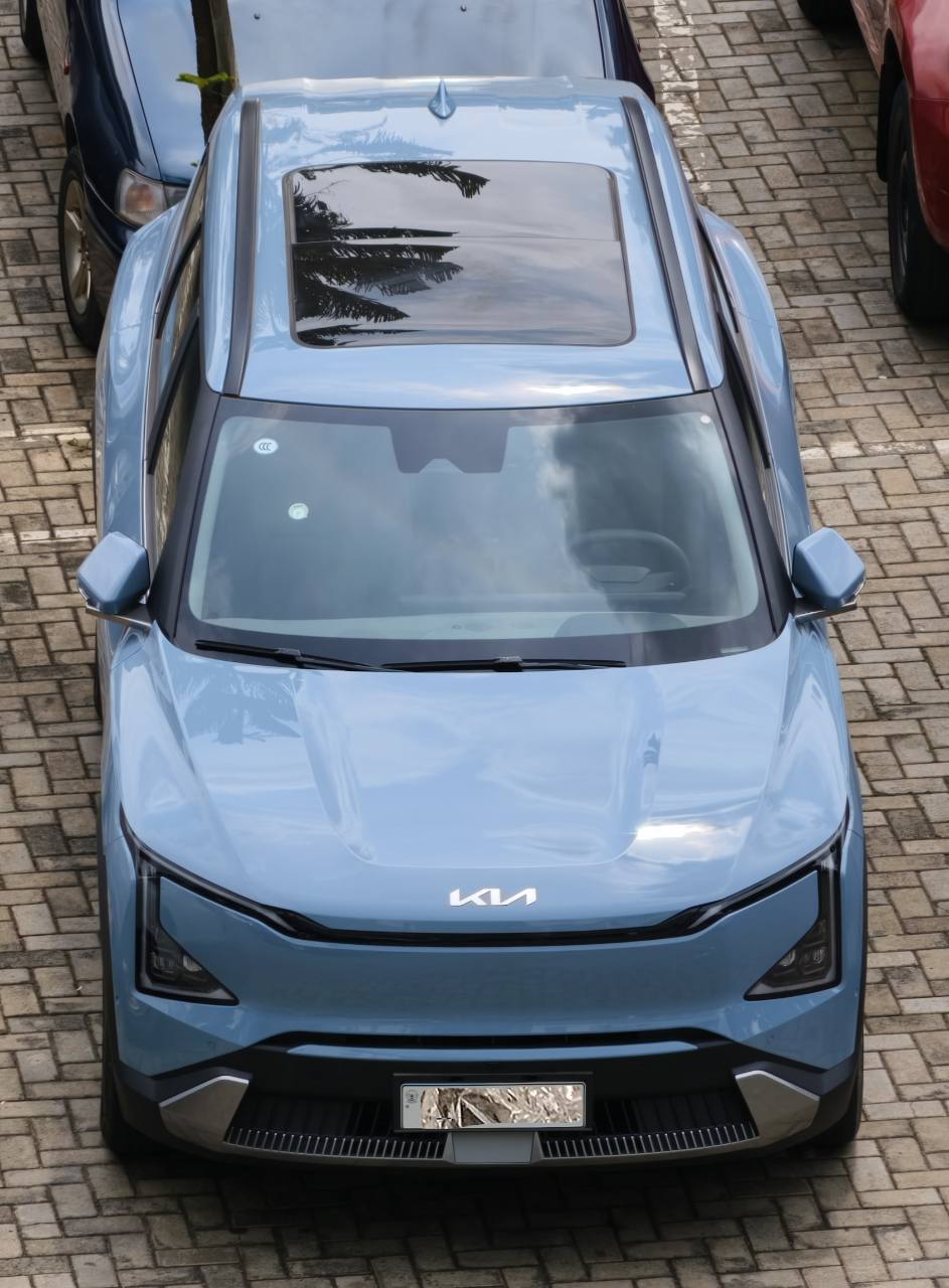 View from above of the client’s light blue Kia EV5 Land, showing its glass roof